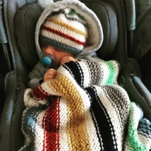 baby with striped hat and blanket