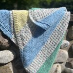 striped baby blanket on stone wall