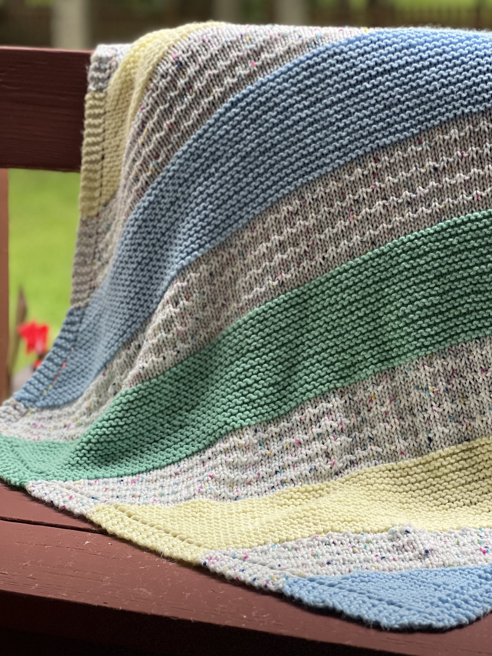 striped baby blanket on bench