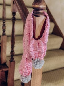 pink scarf with grey pompoms
