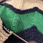 navy green and white handknit blanket in progress