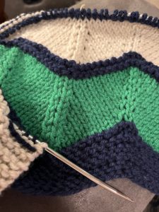 navy green and white handknit blanket in progress