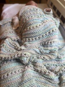 baby wrapped in handknit baby blanket
