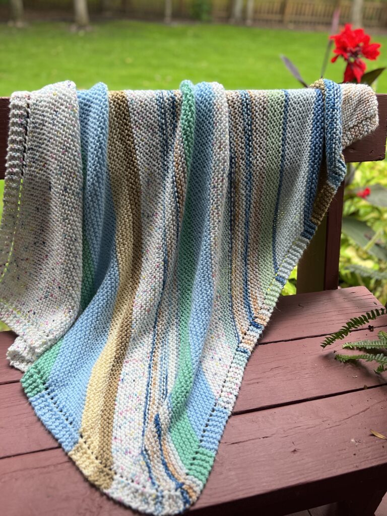 striped handknit blanket on redwood bench