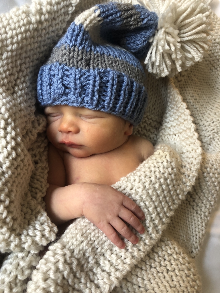 baby with handknit hat and blanket