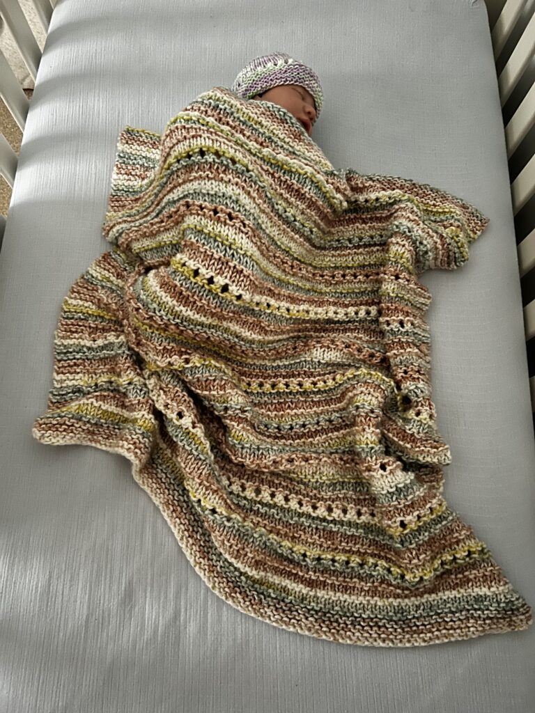 baby sleeping under handknit baby blanket
