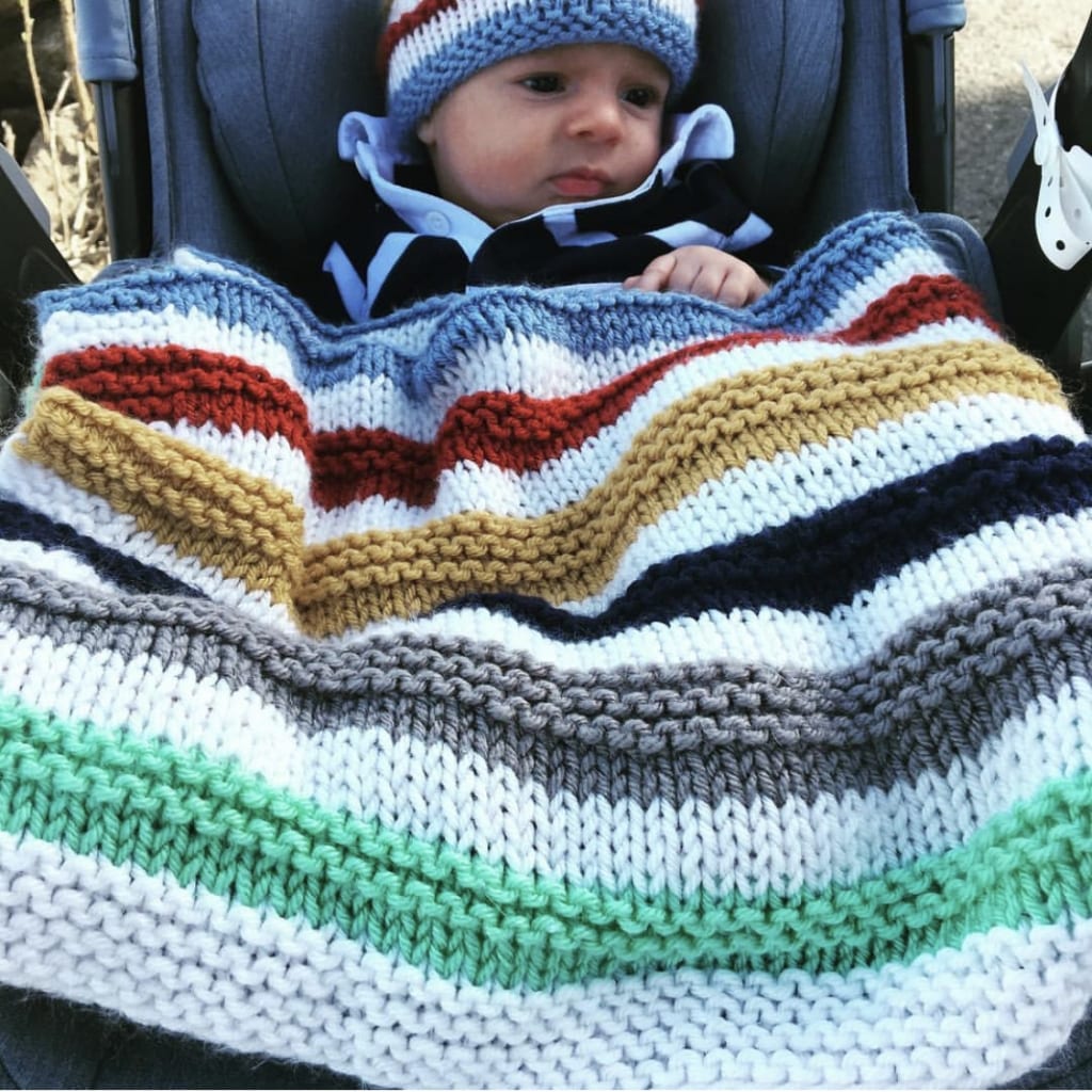 baby with knit blanket