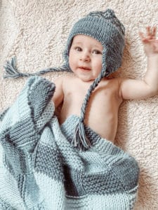 baby with knit hat and blanket