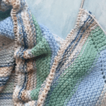 scrappy blanket on knitting needles
