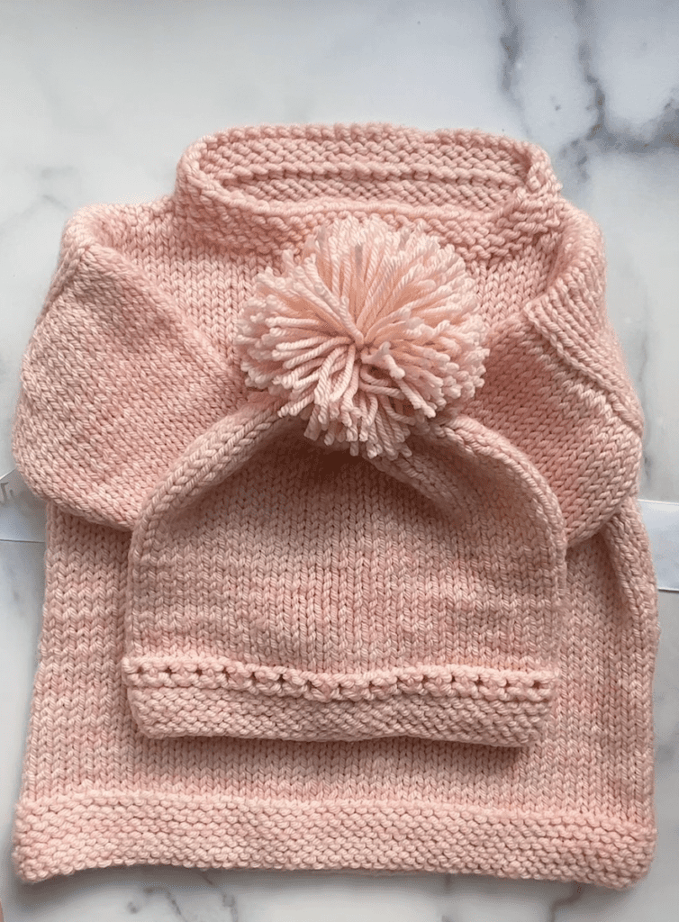 pink sweater and matching pompom hat