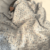 speckled hand knit blanket keeping baby warm