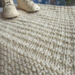 textured blanket and baby shoes