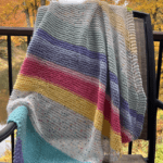 striped baby blanket on chair with fall leaves background