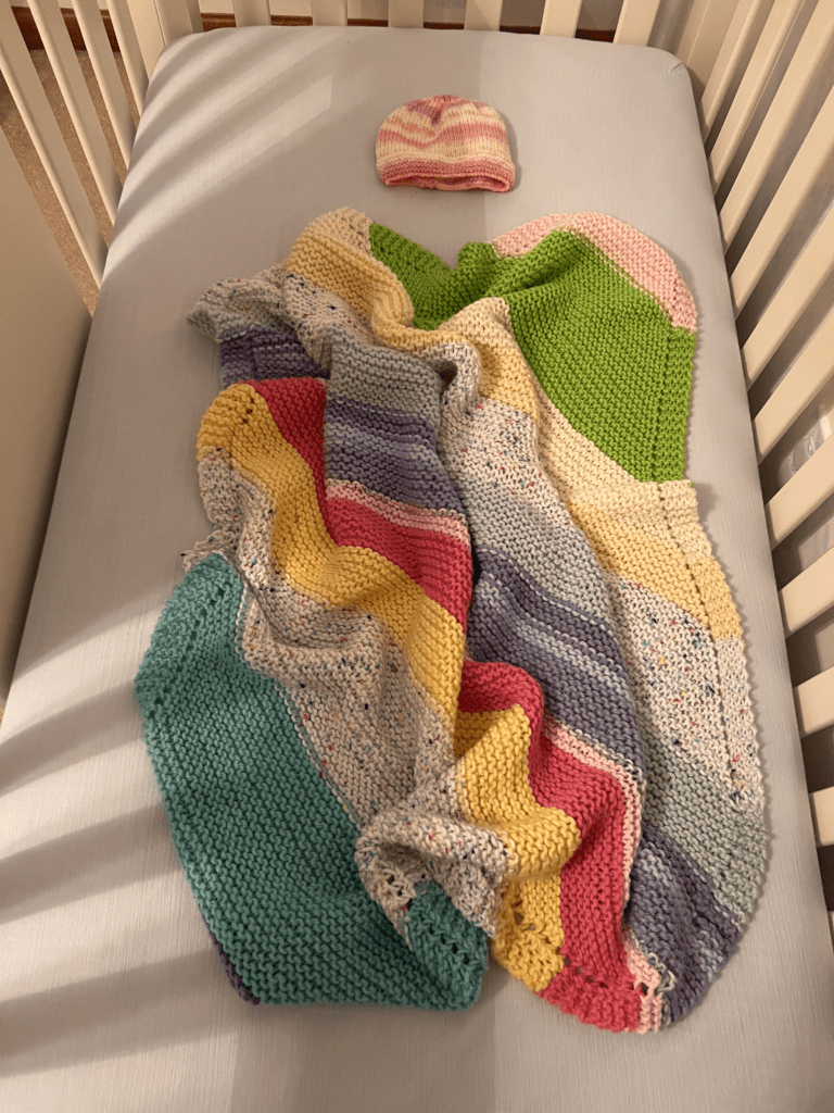 striped baby blanket in crib