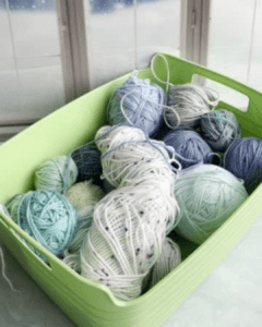 partial skeins of yarn in a green basket