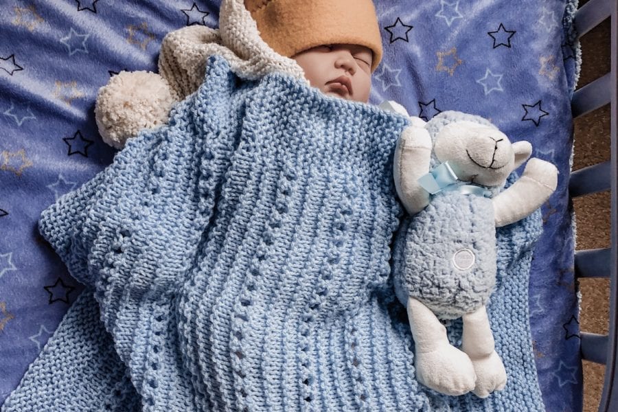 baby sleeping with lamb and baby blanket