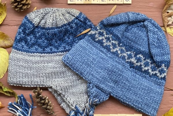 2 blue and gray knit hats with double brim and earflaps