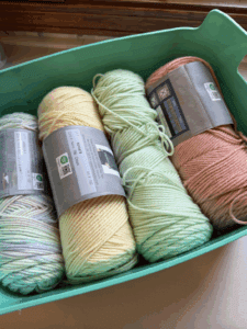 a basket of different colored skeins of yarn used to knit this blanket