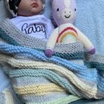 sleeping baby with blanket and doll