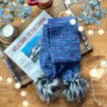 pompom scarf on puzzle table with book