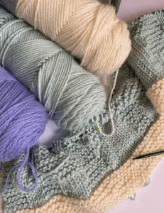 purple, aqua and ivory yarn with knit blanket