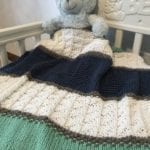 green, blue, white knit blanket with teddy bear