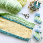 yello aqua and green knit blanket with booties and candle