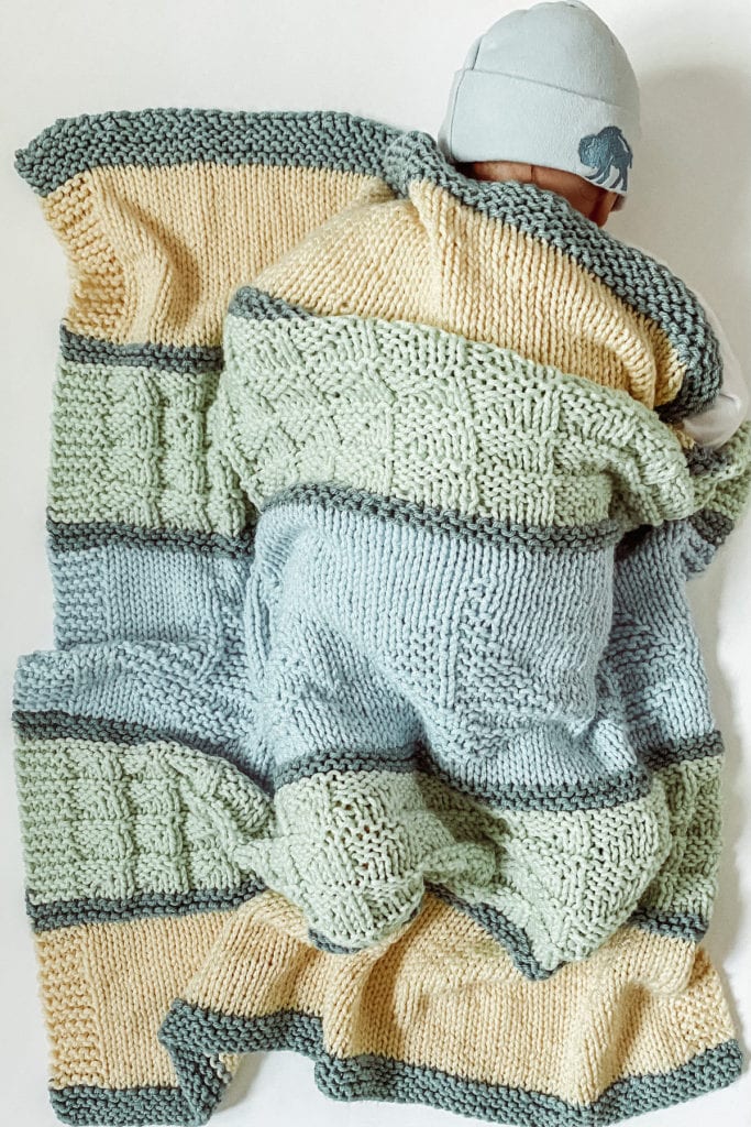 blue, green and yellow handknit blanket with sailboat motif