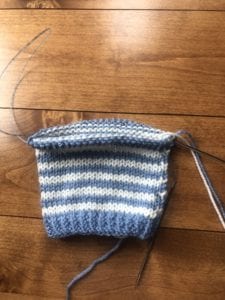 half finished blue and white striped newborn hat