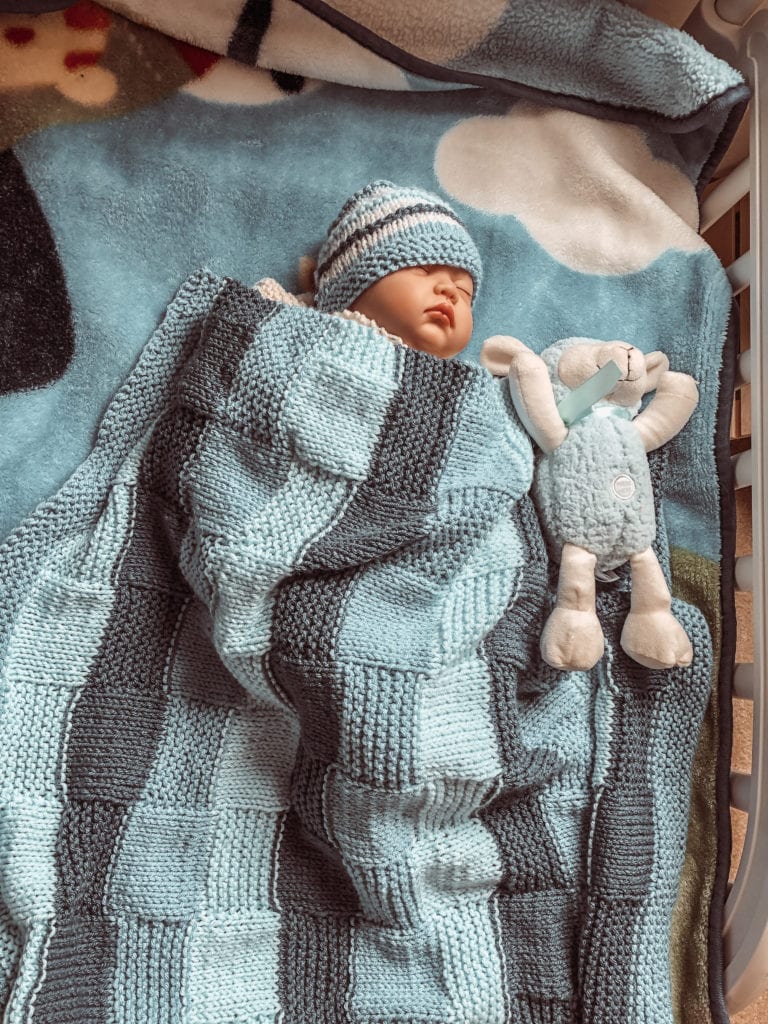 baby with blanket and stuffed animal