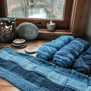 blue striped blanket with rok, coasters and lake view