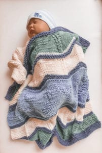 baby sleeping with knit blanket